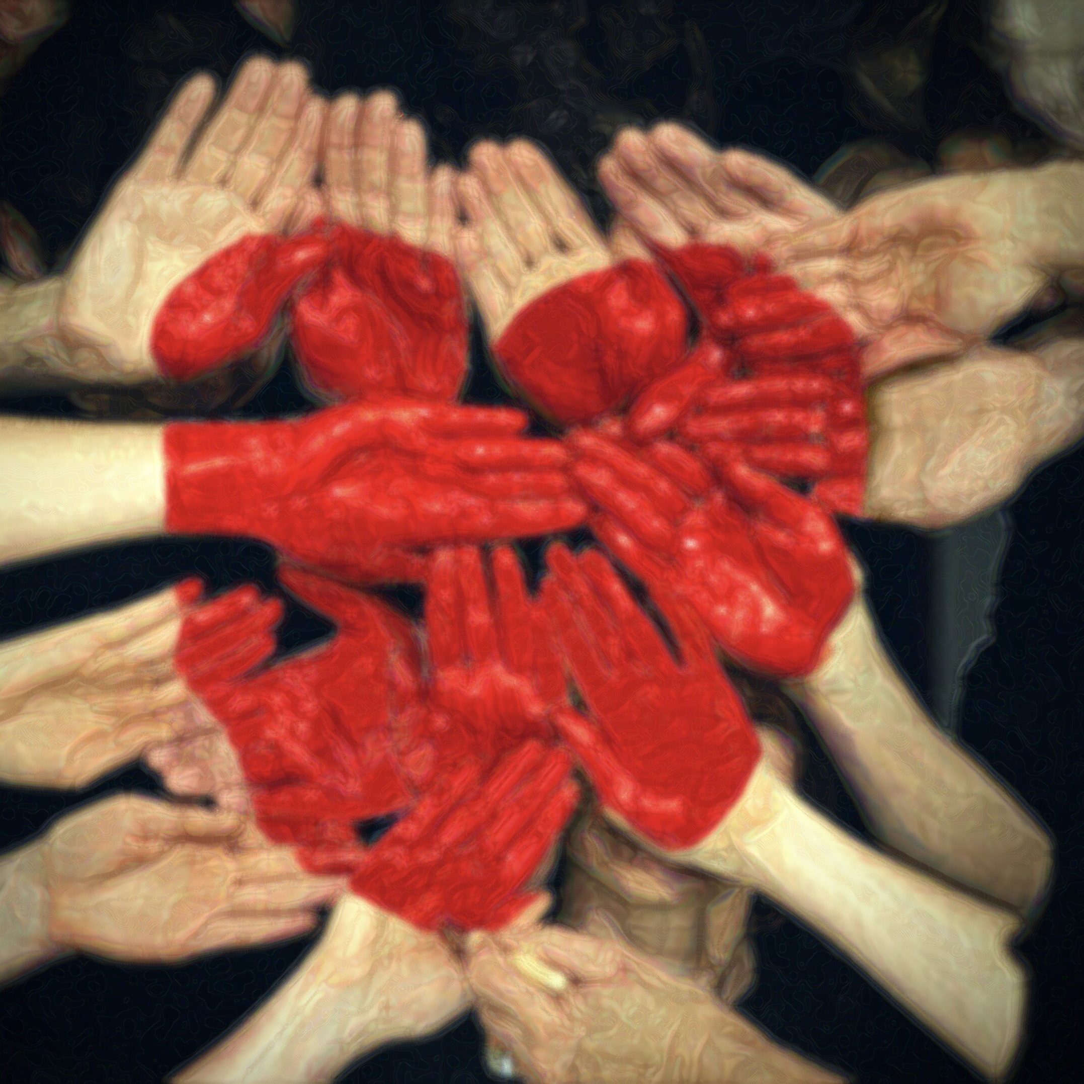 many hands joined with heart shape painted in the middle the group