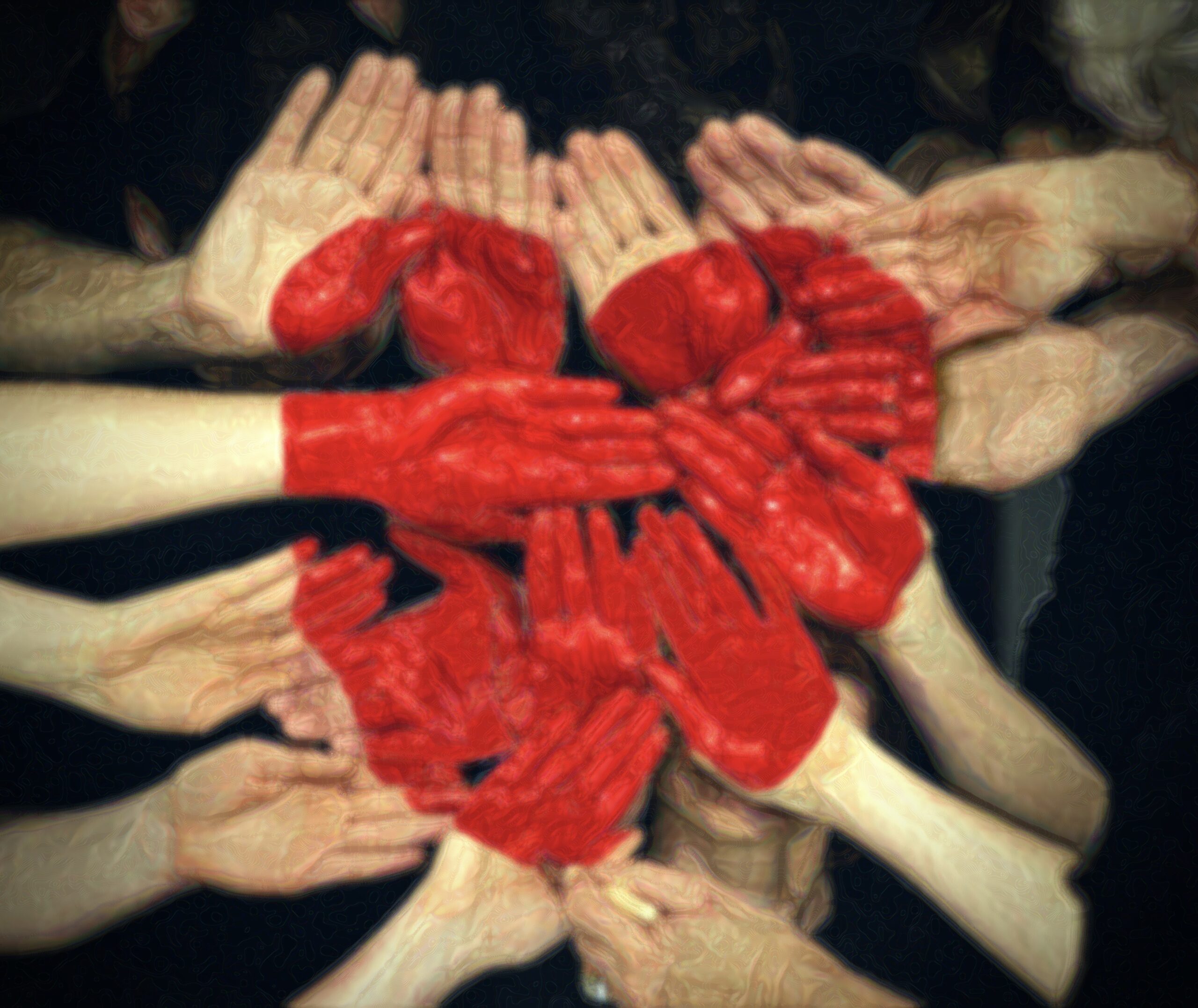 many hands joined with heart shape painted in the middle the group